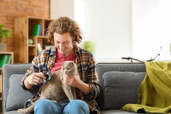 Das Bild zeigt eine Person, die eine Katze liebevoll pflegt und verdeutlicht, wie viel Sorgfalt und Aufmerksamkeit dabei dem Wohlbefinden und Aussehen der Katze gewidmet wird.